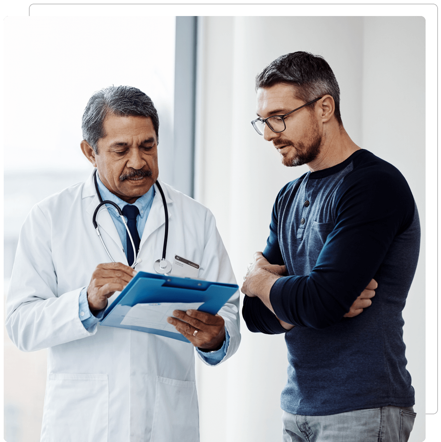Doctor discussing with patient using a clipboard.