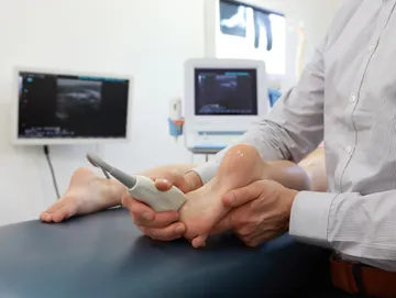 Ultrasound scan on patient's foot in clinic.