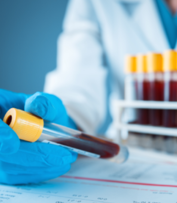 Lab technician handling a blood sample with a test tube.